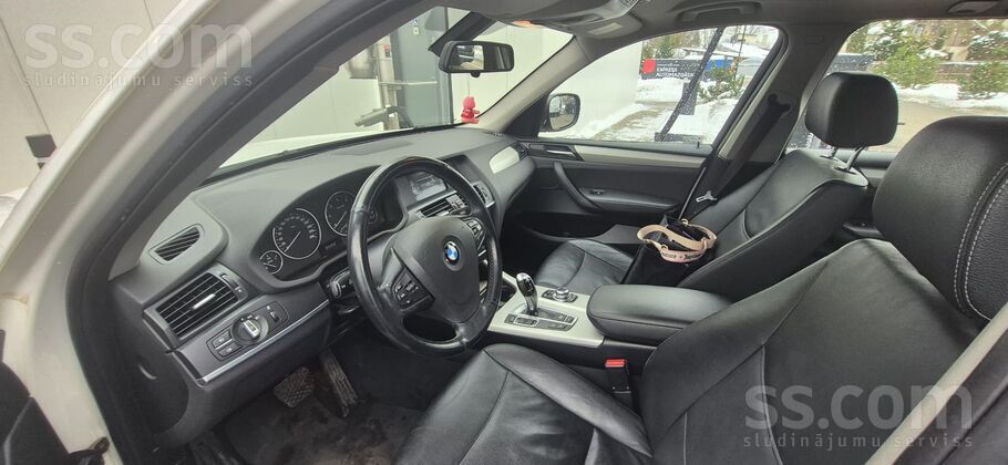 BMW Auto ir balta krāsā ar melnu ādas salonu labā stāv
